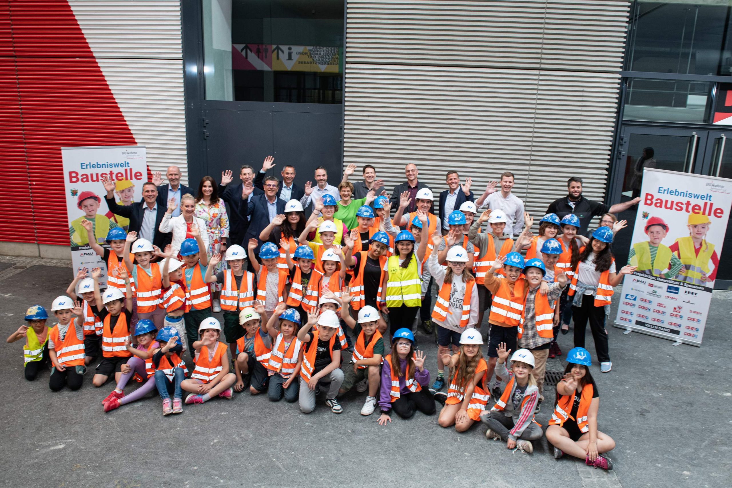 Gruppenfoto mit Kindern und Erwachsenen vor der "Erlebniswelt Baustelle"